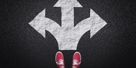 at-a-crossroads–decisions-and-choices-concept-with-large-arrow